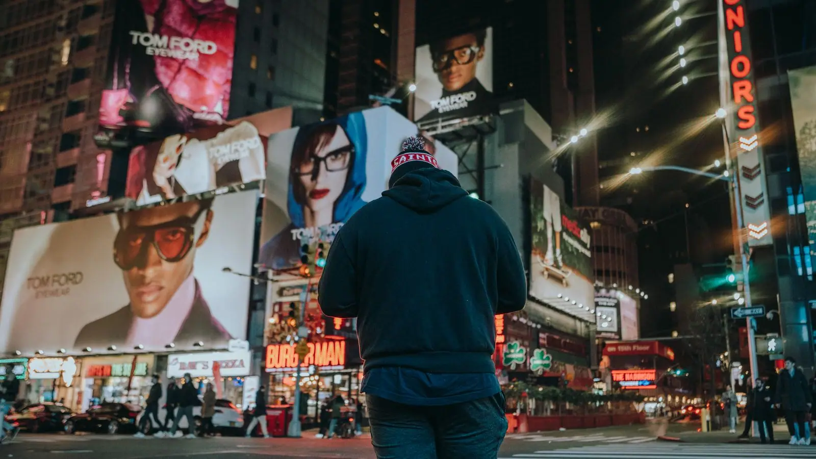 Digital billboards lit up on a city street at night